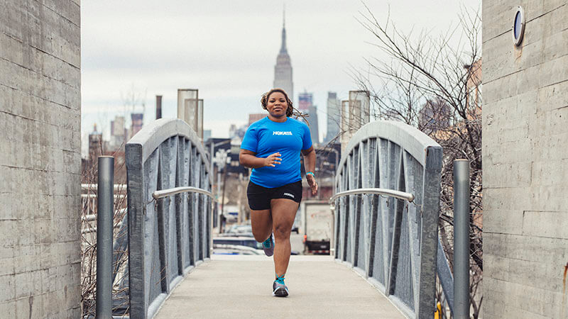 HOKA fan Latoya Snell running over a bridge in New York