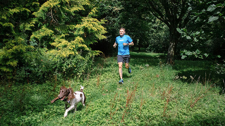 HOKA fan Matthew Pritchard out running with his dog in the forest