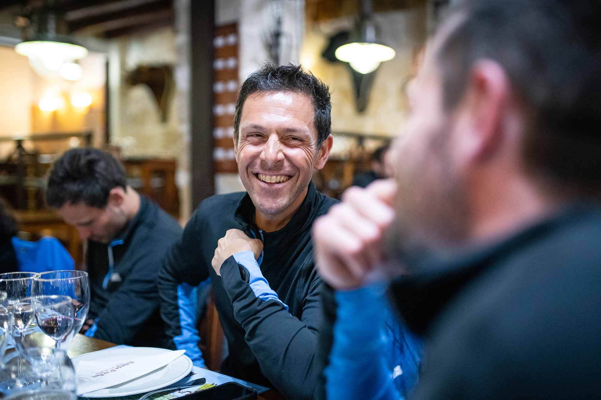 HOKA athlete and team manager Julien Chorier smiling at dinner