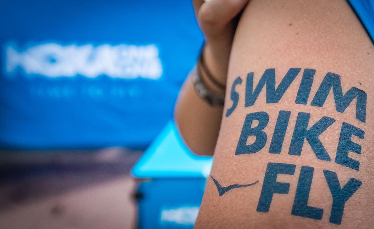 HOKA tattor saying swim, bike, fly